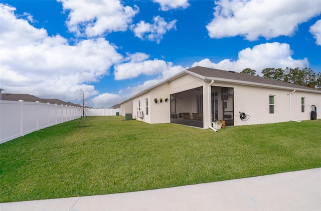 back of property featuring a yard and a sunroom