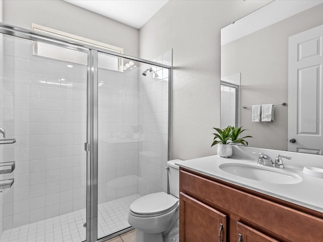 bathroom featuring toilet, vanity, and a shower with shower door