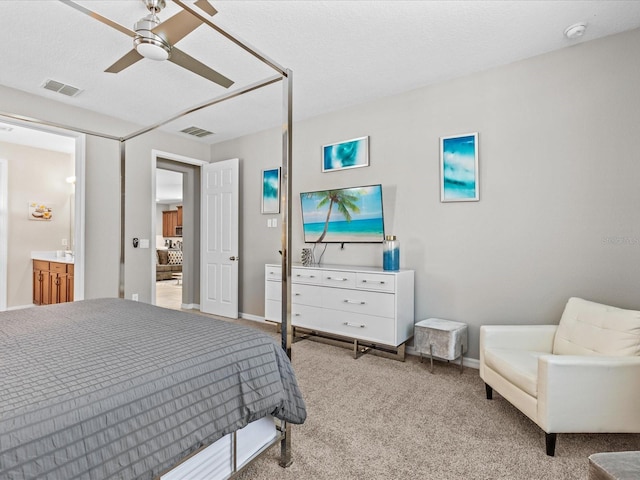 bedroom with light colored carpet, ceiling fan, and a textured ceiling