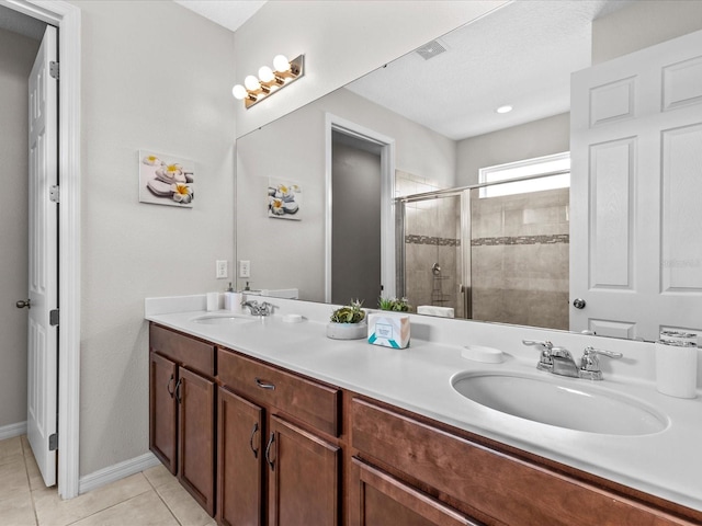 bathroom featuring a shower with door, vanity, and tile patterned flooring