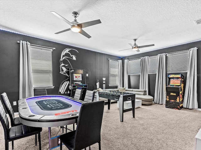 recreation room with ceiling fan, carpet, and a textured ceiling