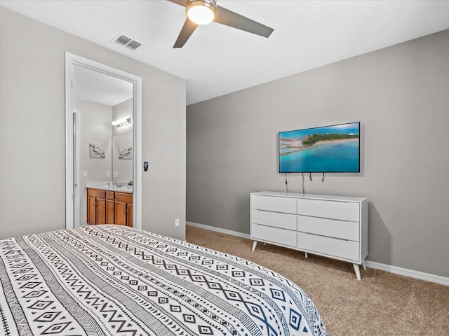 carpeted bedroom with ceiling fan and ensuite bath