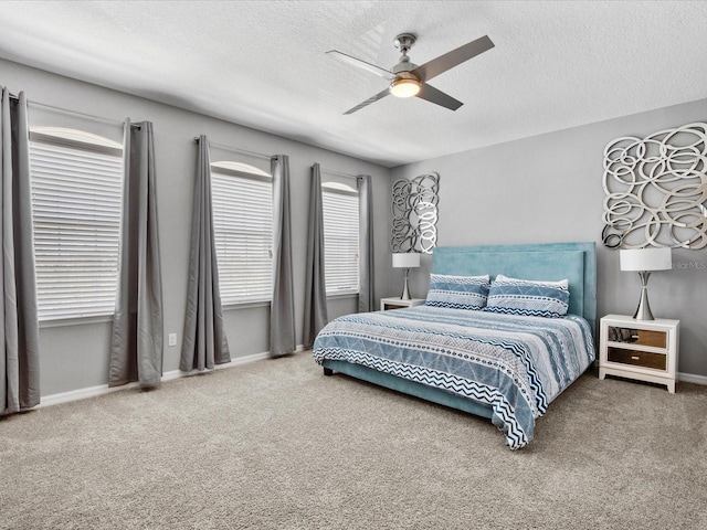 bedroom featuring a textured ceiling, ceiling fan, and carpet