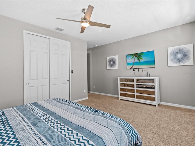 carpeted bedroom featuring a textured ceiling, ceiling fan, and a closet