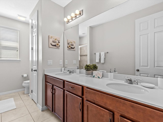 bathroom with tile patterned flooring, a shower with shower door, vanity, and toilet