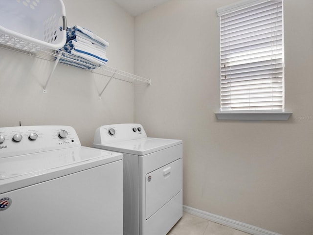 laundry area with washing machine and dryer and light tile patterned floors