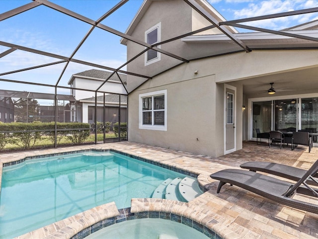 view of pool with ceiling fan, an in ground hot tub, glass enclosure, and a patio