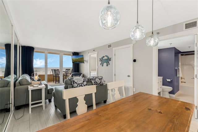 dining space with expansive windows and a water view