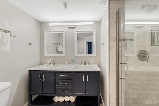 bathroom featuring vanity, toilet, and a shower with door