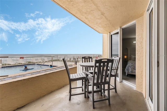 balcony featuring a water view and a view of the beach