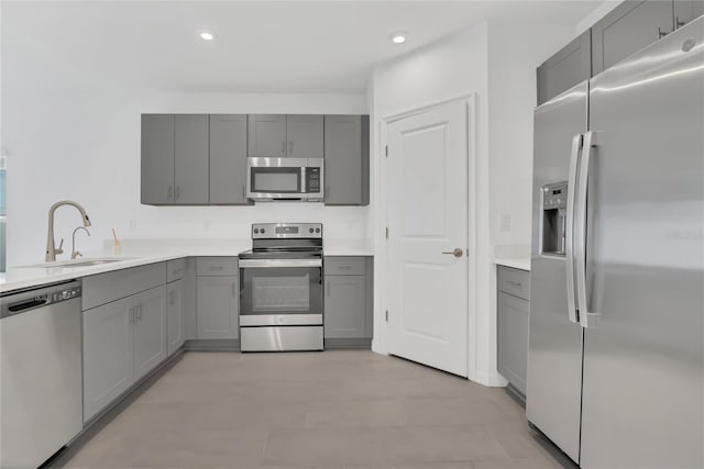 kitchen with gray cabinets, appliances with stainless steel finishes, and sink