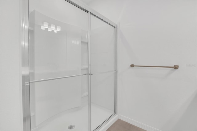 bathroom featuring tile patterned floors and a shower with shower door