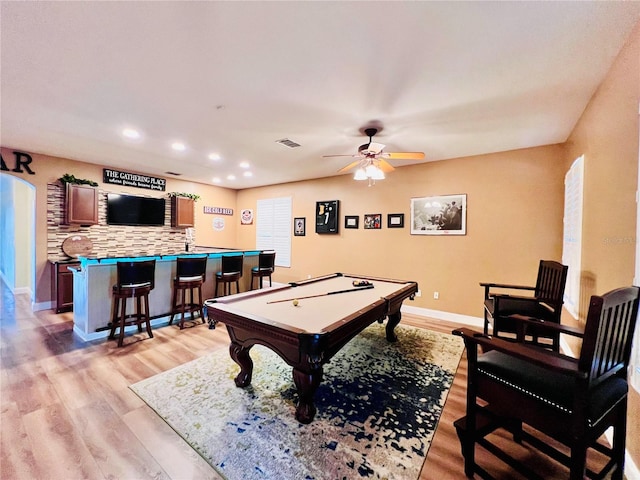 rec room with ceiling fan, light hardwood / wood-style floors, bar area, and billiards