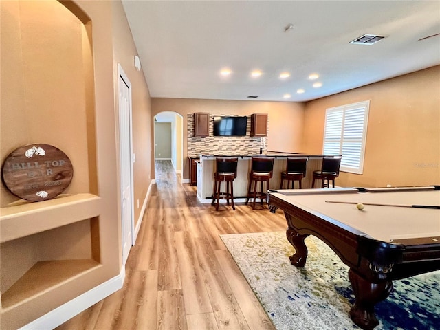 playroom with pool table, bar, and light hardwood / wood-style floors