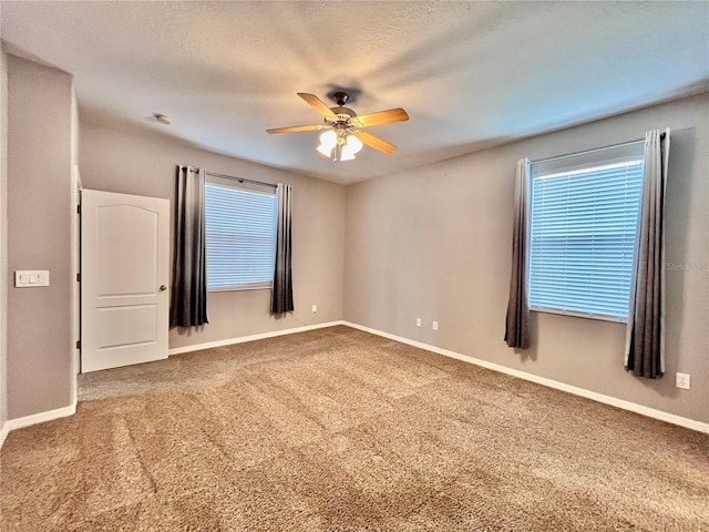 unfurnished room featuring a textured ceiling, ceiling fan, and carpet flooring