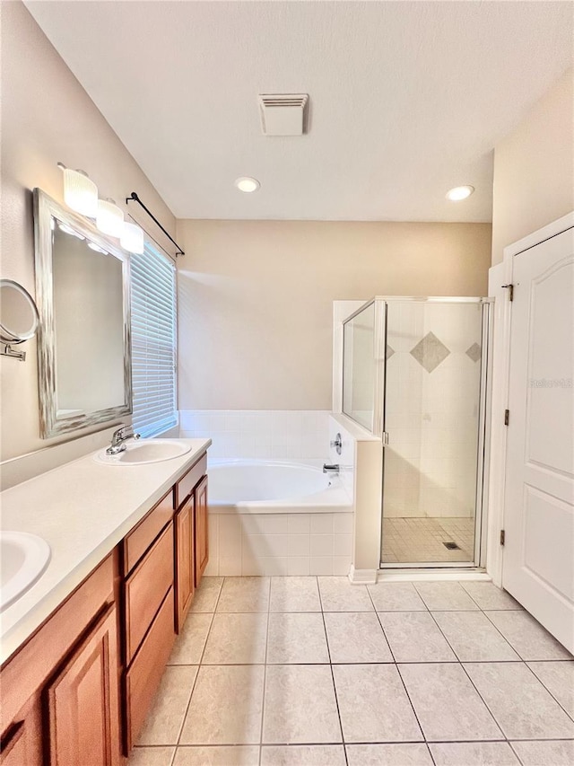 bathroom with vanity, tile patterned flooring, and plus walk in shower