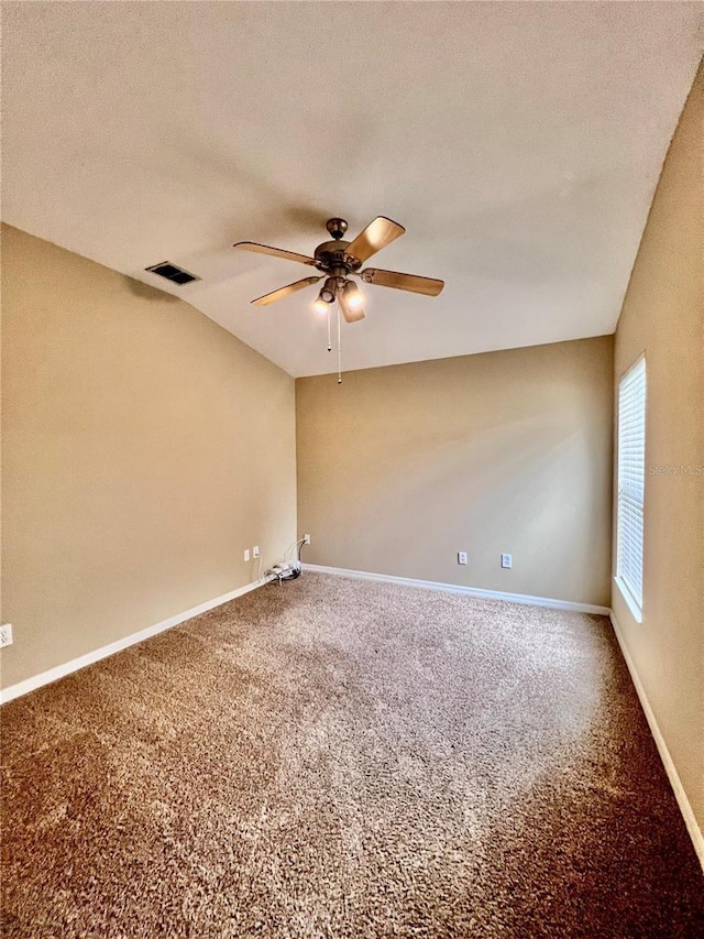 carpeted empty room featuring vaulted ceiling, ceiling fan, and a textured ceiling