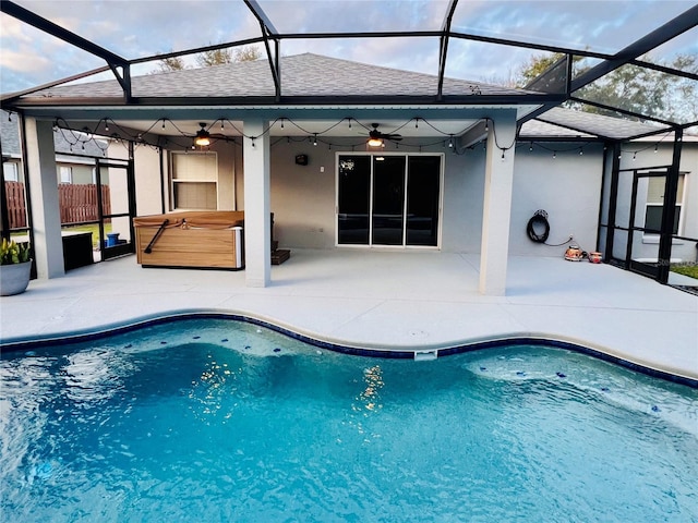 view of swimming pool with ceiling fan, a hot tub, and a patio area