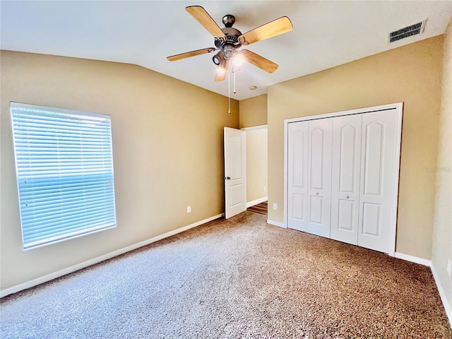 unfurnished bedroom featuring vaulted ceiling, ceiling fan, carpet flooring, and a closet