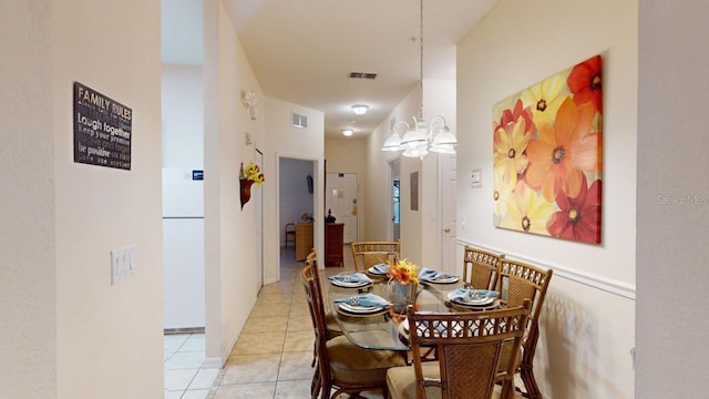 dining room featuring light tile patterned flooring and a chandelier