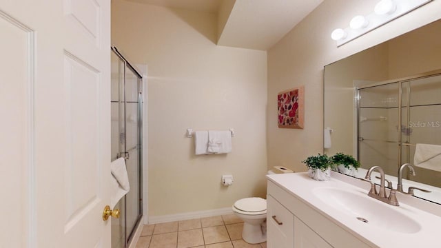 bathroom with tile patterned floors, vanity, toilet, and a shower with shower door