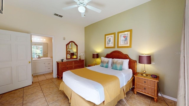 bedroom featuring ceiling fan, light tile patterned floors, and ensuite bath