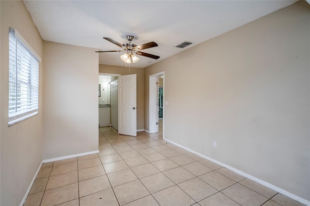 tiled spare room featuring ceiling fan