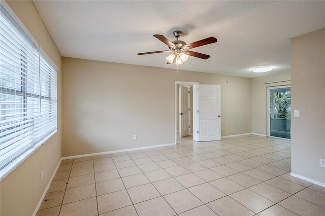 tiled empty room featuring ceiling fan