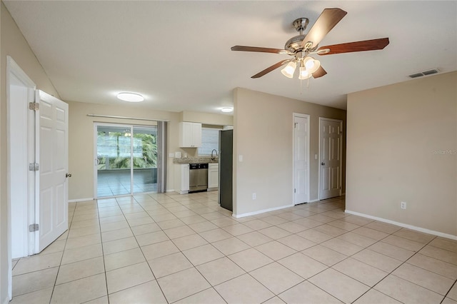 tiled spare room with sink and ceiling fan