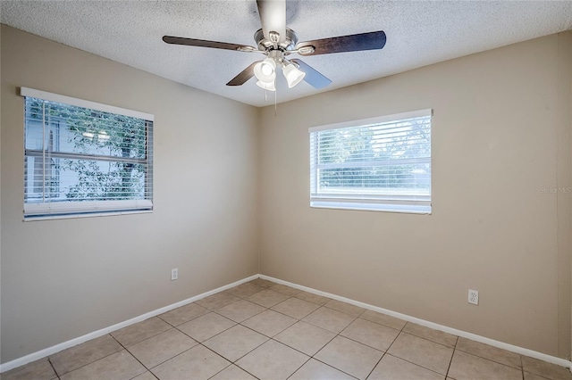 spare room with ceiling fan, a textured ceiling, and light tile patterned floors