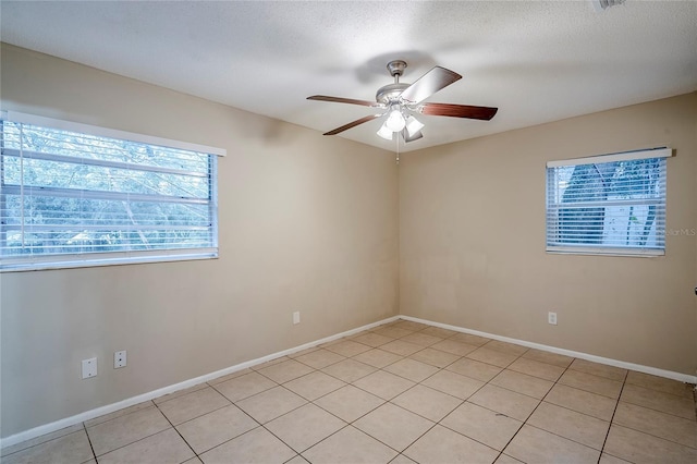 tiled empty room with a textured ceiling and ceiling fan