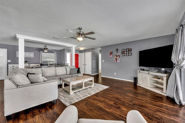 living room with a textured ceiling, hardwood / wood-style flooring, and ceiling fan