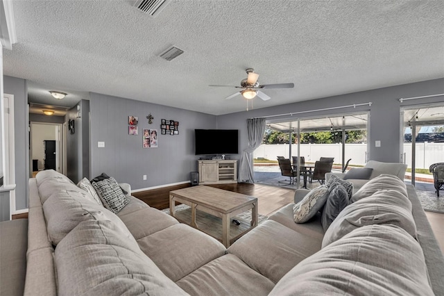 living room featuring hardwood / wood-style floors, a textured ceiling, and ceiling fan