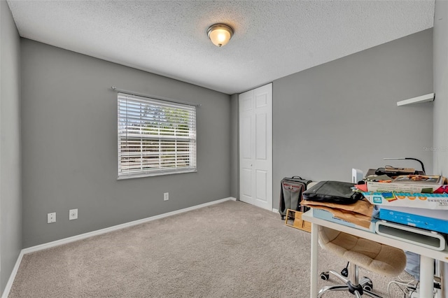 carpeted home office with a textured ceiling