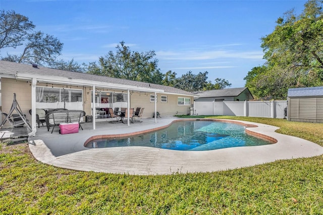 view of pool featuring a storage unit, a patio area, and a lawn