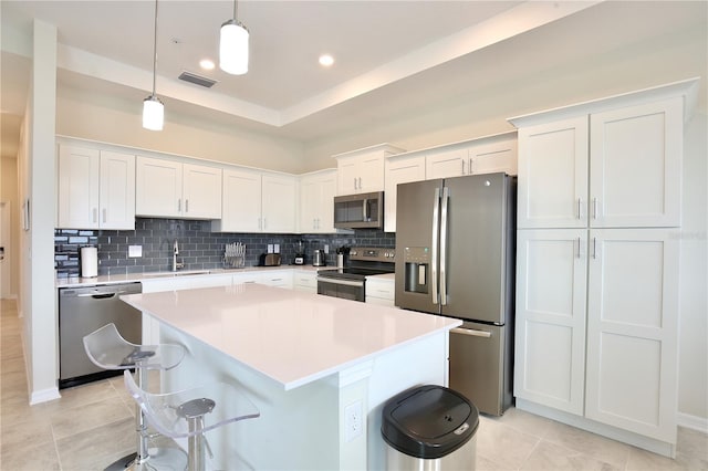 kitchen with white cabinets, appliances with stainless steel finishes, pendant lighting, and sink