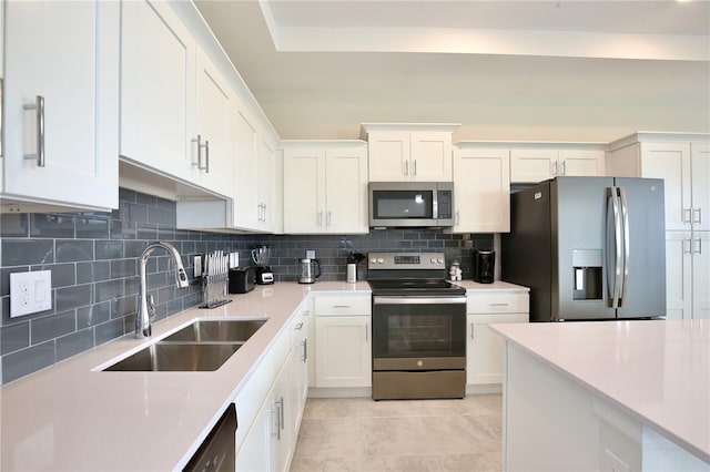 kitchen with stainless steel appliances, light tile patterned floors, decorative backsplash, sink, and white cabinetry