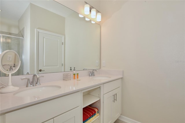 bathroom featuring a shower with shower door and vanity