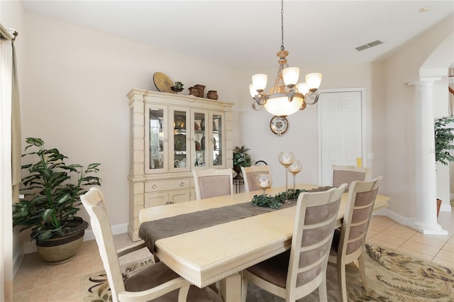 tiled dining room with an inviting chandelier and ornate columns