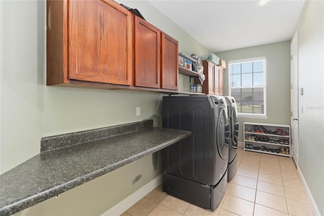 laundry room with cabinets, washing machine and dryer, and light tile patterned floors