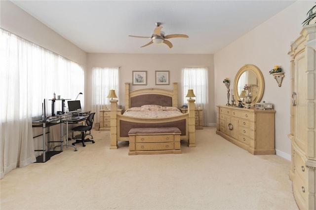 bedroom with multiple windows, ceiling fan, and light colored carpet