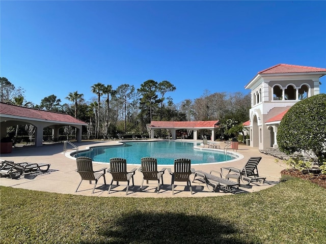 view of swimming pool featuring a patio and a lawn