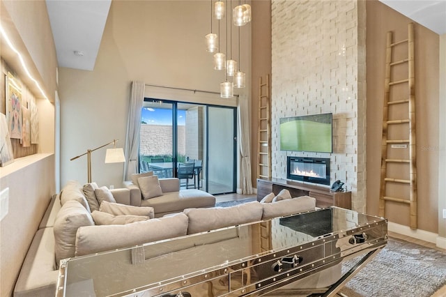 living room with a towering ceiling, a fireplace, and hardwood / wood-style floors