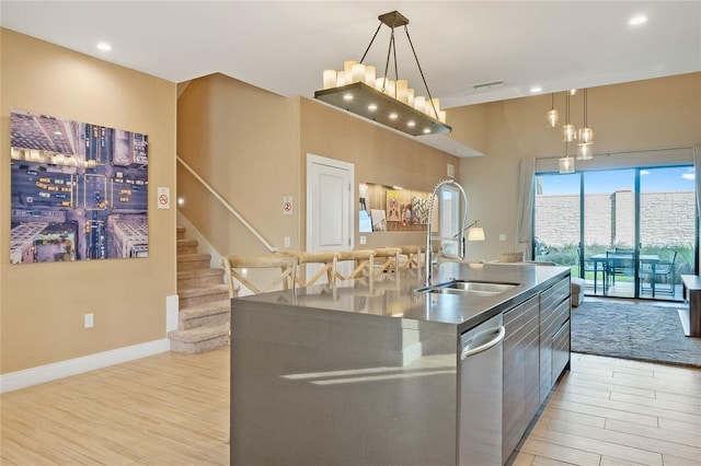 kitchen featuring sink, pendant lighting, and a large island with sink