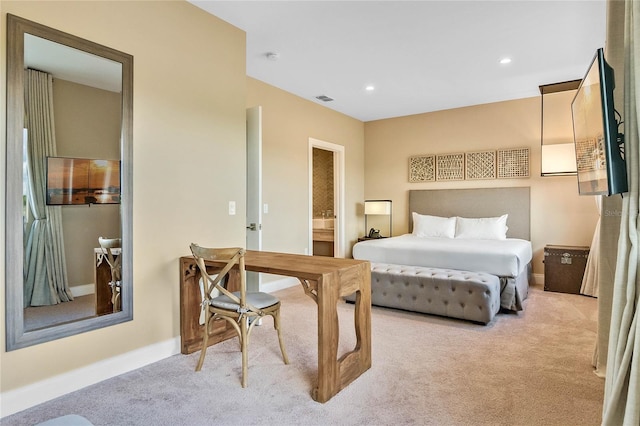 bedroom featuring ensuite bath and light carpet