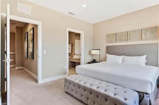 carpeted bedroom featuring ensuite bath