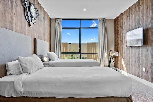 bedroom featuring wooden walls and carpet flooring