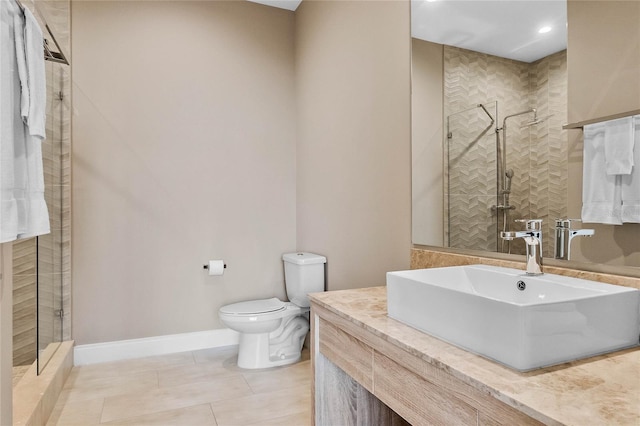 bathroom featuring toilet, vanity, tile patterned flooring, and tiled shower