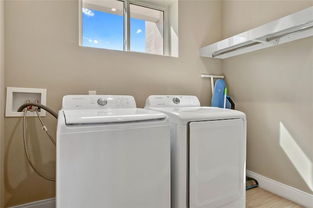 laundry room with washer and clothes dryer and light wood-type flooring