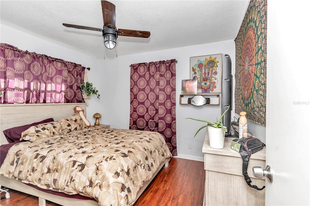 bedroom with dark wood-type flooring, a textured ceiling, and ceiling fan